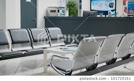Professional waiting room with chairs in clinic hallway, reception counter used to solve patients registration before medical appointment. Empty reception counter desk in health center. Professional waiting room with chairs in clinic hallway, reception counter used to solve patients registration before medical appointment. Empty reception counter desk in health center. 101720161