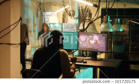 Happy thief successfully breaking network system on computer, doing hacking, cyberwarfare and espionage work at night. Criminal being congratulated about cryptojacking achievement. 101720175