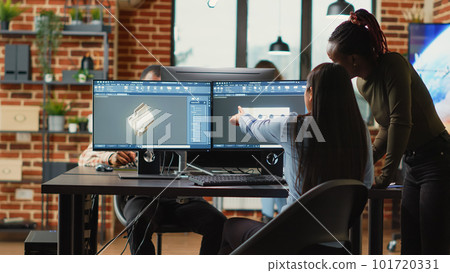 Team of diverse women brainstorming ideas to develop industrial clamp, doing teamwork to create mechanical prototype with cad software. Young technicians working in manufacturing industry. Team of diverse women brainstorming ideas to develop industrial clamp, doing teamwork to create mechanical prototype with cad software. Young technicians working in manufacturing industry. 101720331