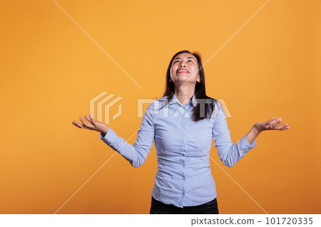 Faithful filipino woman standing with palms faced to sky, asking god for better life in studio over yellow background. Hopeful religious young adult showing gratitude, praying for peace Faithful filipino woman standing with palms faced to sky, asking god for better life in studio over yellow background. Hopeful religious young adult showing gratitude, praying for peace 101720335