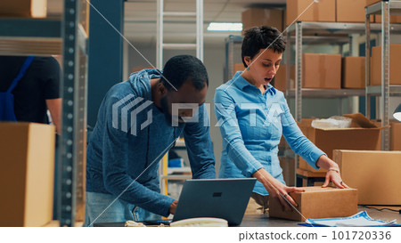 Owners team shipping merchandise from storehouse stock and doing quality control. Man and woman working on small business with products shipment, startup distribution. Handheld shot. 101720336