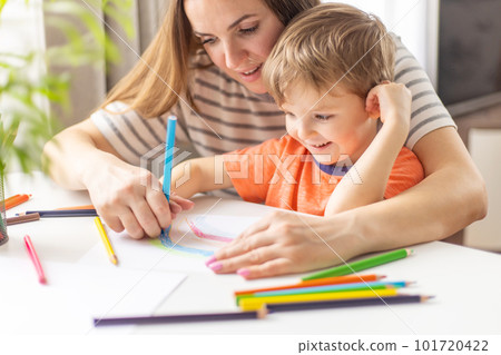Mother and child drawing with pencils sitting at the desk at home Mother and child drawing with pencils sitting at the desk at home 101720422