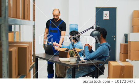 Team of entrepreneurs preparing merchandise order in storage room, woman signing delivery logistics papers. Startup owners using warehouse stock to ship to customers, financial planning. Team of entrepreneurs preparing merchandise order in storage room, woman signing delivery logistics papers. Startup owners using warehouse stock to ship to customers, financial planning. 101720475