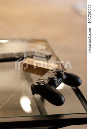 video game controller on glass table. gaming, technology and entertainment concept - blue gamepad controller on table 101720902