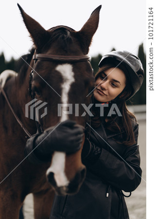 A young equestrian in uniform poses with a beautiful, majestic horse. 101721164