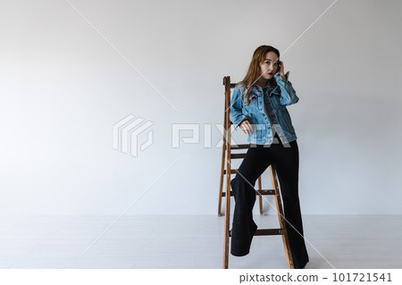 A quirky woman leaning on a stepladder brown hair flared leg pants A quirky woman leaning on a stepladder brown hair flared leg pants 101721541