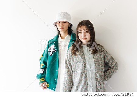 A stylish couple leaning against a white wall A stylish couple leaning against a white wall 101721954