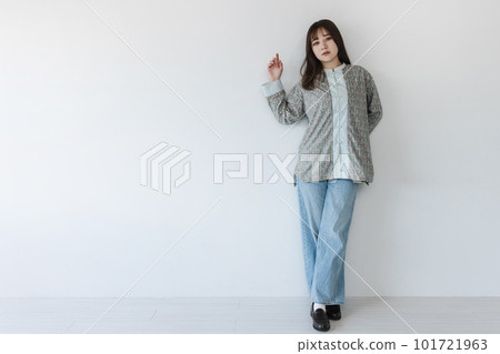 A half-Japanese young woman posing in front of a white wall A half-Japanese young woman posing in front of a white wall 101721963