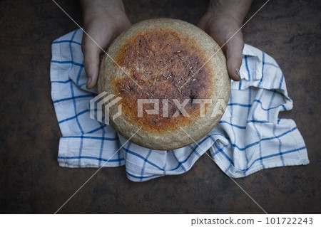 Homemade crusty loave of bread on wooden background. Baker holding fresh bread in the hands. view Homemade crusty loave of bread on wooden background. Baker holding fresh bread in the hands. view 101722243