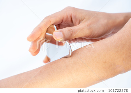 Female hand massaging arm with metal massage plate 101722278