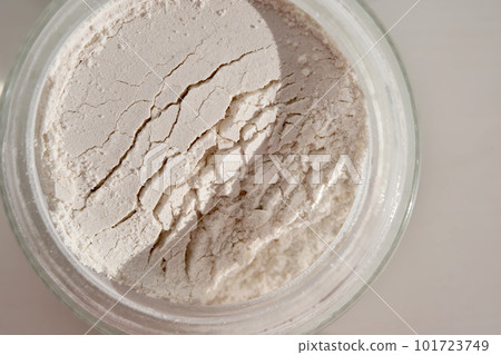 An open jar of face scrub-powder showing off its texture. 101723749