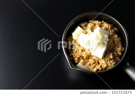 A bird's-eye view shot of spicy mapo tofu with plenty of tofu on a black background A bird's-eye view shot of spicy mapo tofu with plenty of tofu on a black background 101723875