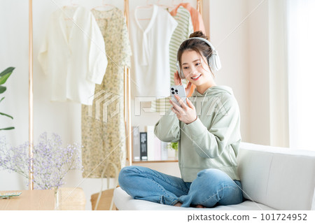 Young woman listening to music in the living room Young woman listening to music in the living room 101724952
