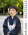 A 5-year-old child wearing a kimono and visiting the Shichi-go-san shrine stands in the precincts of a shrine with a chin mask. 101725213