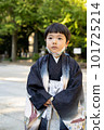 A 5-year-old child wearing a kimono and visiting the Shichi-go-san shrine stands in the precincts of a shrine with a chin mask. 101725214
