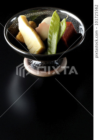 Shoot a simmered dish containing bamboo shoots, taro, namafu, snow peas, etc. against a black background 101725562