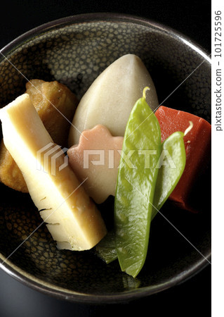 A bird's-eye view of a simmered dish containing bamboo shoots, taro, namafu, snow peas, etc. against a black background A bird's-eye view of a simmered dish containing bamboo shoots, taro, namafu, snow peas, etc. against a black background 101725596