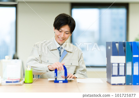 Business woman wearing work clothes punching a hole 101725877