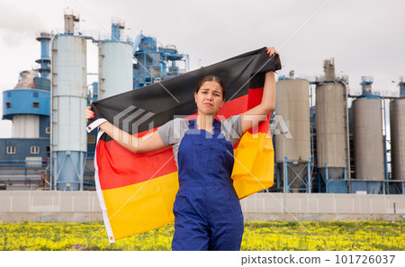 Sad young woman near factory with Germany flag 101726037