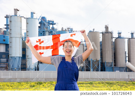Smiling young woman near factory with flag of Georgia Smiling young woman near factory with flag of Georgia 101726043