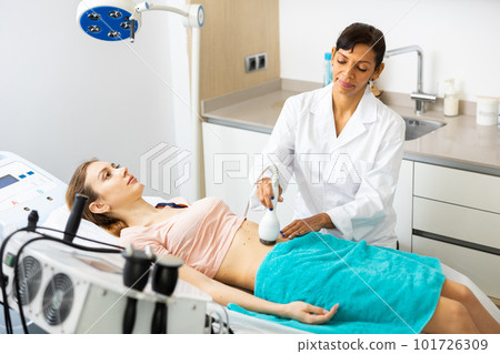 Woman cosmetologist making ultrasound lifting procedure Woman cosmetologist making ultrasound lifting procedure 101726309