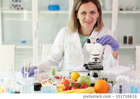 Chemist examines vitamin capsules working in laboratory 101726618