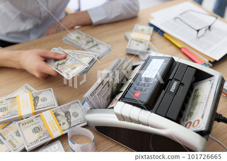 Woman uses bill counter to count money after profitable deal Woman uses bill counter to count money after profitable deal 101726665