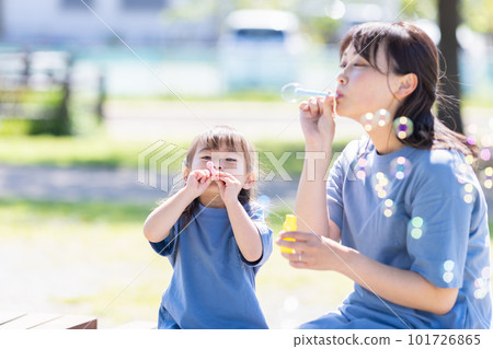 Parents and children playing with soap bubbles Parents and children playing with soap bubbles 101726865