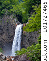 A waterfall where a large amount of water flows down from the rugged rock face 101727465