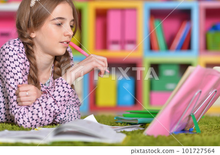 Little girl drawing with pencil in her room 101727564