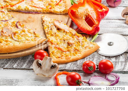 Pizza with chicken, paprika and corn. Italian kitchen and cooking concept. Chief with a pizza cutter cutting pizza to pieces at Neapolitan pizzeria. 101727708