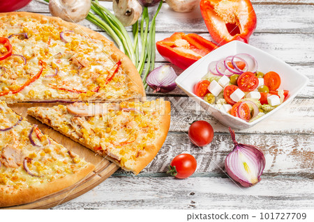 Pizza with chicken, paprika and corn. Italian kitchen and cooking concept. Chief with a pizza cutter cutting pizza to pieces at Neapolitan pizzeria. 101727709