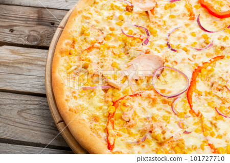 Pizza with chicken, paprika and corn. Italian kitchen and cooking concept. Chief with a pizza cutter cutting pizza to pieces at Neapolitan pizzeria. 101727710