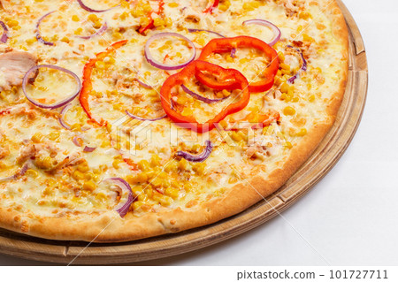 Pizza with chicken, paprika and corn. Italian kitchen and cooking concept. Chief with a pizza cutter cutting pizza to pieces at Neapolitan pizzeria. 101727711