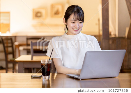 Asian business woman teleworking and working using a computer at a cafe or coffee shop 101727836