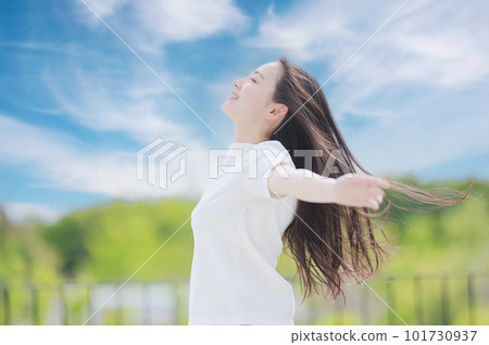 A woman stretching towards the blue sky 101730937