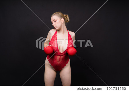 Seductive young and fit female fighter posing in gloves in studio Seductive young and fit female fighter posing in gloves in studio 101731260