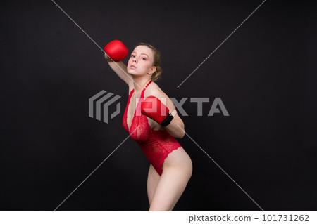 Seductive young and fit female fighter posing in gloves in studio Seductive young and fit female fighter posing in gloves in studio 101731262