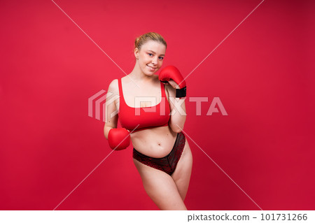 Seductive young and fit female fighter posing in gloves in studio 101731266