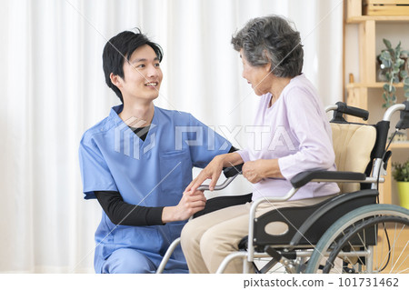 Physical therapist rehabilitating a senior woman on a wheelchair Physical therapist rehabilitating a senior woman on a wheelchair 101731462