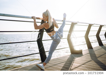 Fitness woman doing sports exercises at the beach pier. Healthy lifestyle. Sport, Active life. 101731994