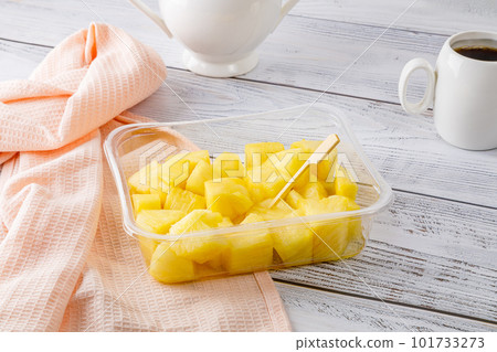 Pineapple fruit salad in a plastic container on a wooden background. Pineapple fruit salad in a plastic container on a wooden background. 101733273