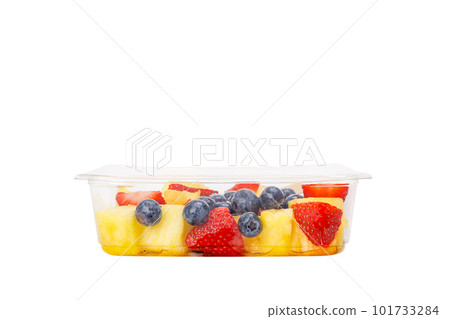 Fruit salad with pineapple, strawberries and blueberries in a plastic container on a white background. Fruit salad with pineapple, strawberries and blueberries in a plastic container on a white background. 101733284