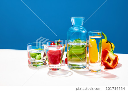 Still life with broccoli, red and yellow pepper on table with bottle of water over blue studio background. Juicy vegetables salad Still life with broccoli, red and yellow pepper on table with bottle of water over blue studio background. Juicy vegetables salad 101736334