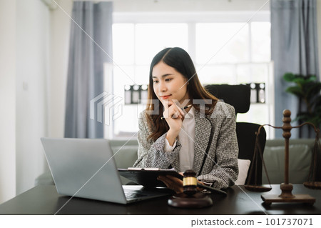 Beautiful asian woman lawyer working and gavel, tablet, laptop in front, Advice justice and law concept. in office. 101737071