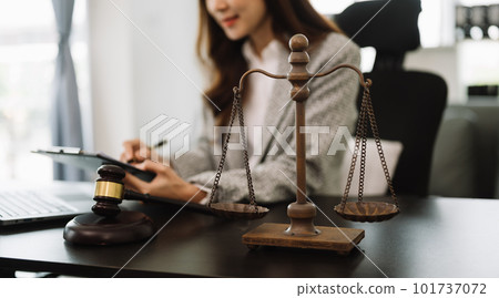 justice and law concept.law theme  wooden desk, books, balance. Male judge in a courtroom the gavel,working with digital tablet computer on table 101737072