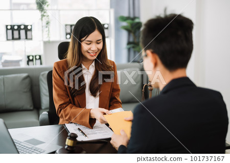 justice and law concept.passing bribe money in the envelop at office. businesswoman hand taking bribe money from male. justice and law concept.passing bribe money in the envelop at office. businesswoman hand taking bribe money from male. 101737167