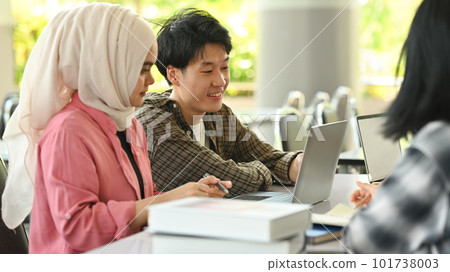 University students collaborating on a project in campus. Education, Learning and technology concept University students collaborating on a project in campus. Education, Learning and technology concept 101738003