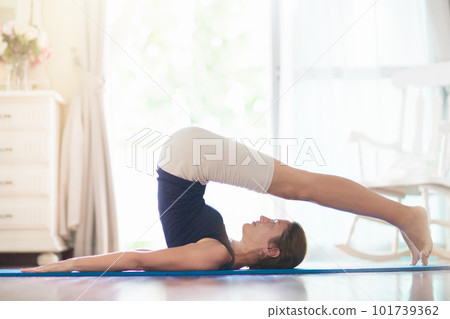 Yoga exercise at home. Fit woman stretching on mat Yoga exercise at home. Fit woman stretching on mat 101739362
