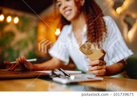 Young woman sitting at cafe making online shopping, using credit card and laptop. Online shopping 101739675